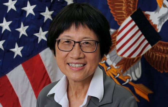 heidi shyu smiling in front of a flag